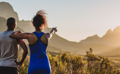 Shot of a sporty young couple looking at the view while out in nature setting bold goals