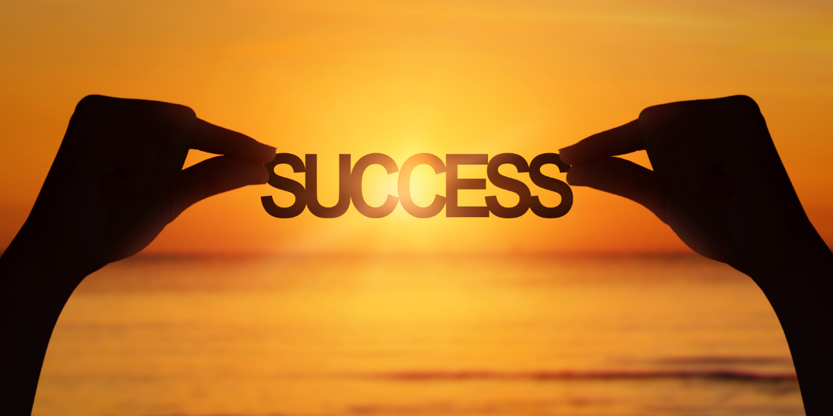 Hands holding success text in sea sunset, Effective Goal Tracking Strategies
